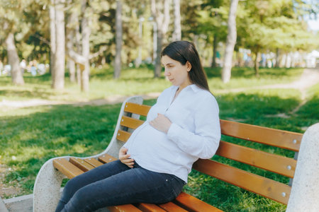 Expecting Mother Enjoying Peaceful Day Alone in Green City Parkの写真素材
