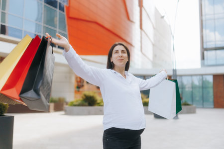 Young pregnant woman enjoys shopping while embracing motherhoodの写真素材