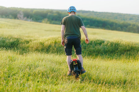Man Riding Electric Unicycle in Green Field with Helmet On