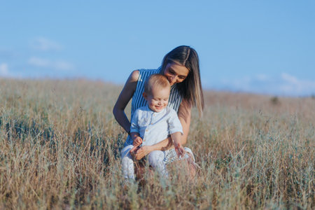 Mother and child connect through play in nature during summer dayの写真素材