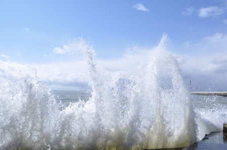 Sea waves breaking on concrete port の写真素材