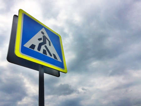 Road sign "pedestrian crossing" on a dark storm sky background. Copy spaceの写真素材
