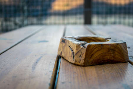 Wooden ashtray on a wooden tableの写真素材