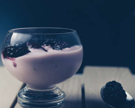 Pink fruit yogurt with blackberries and spoonの写真素材