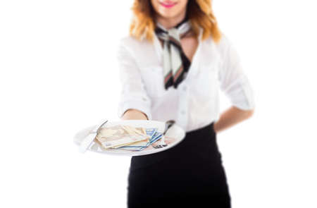 Businesswoman with a plate full of money isolated on whiteの写真素材