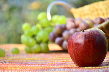 red apple and grapes on a tableの写真素材
