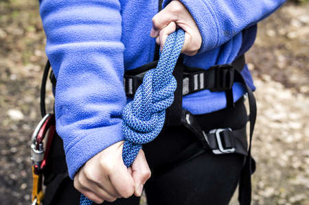 female hands holding a climbing rope with a secure nodeの写真素材