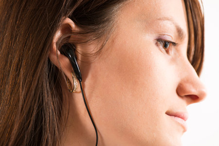 Young women with headphones on white background