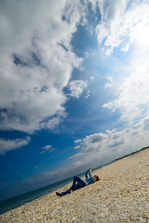Young woman relaxing on a beach against blue sky on a summer day