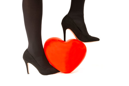 Woman steps on a heart balloon with her heels