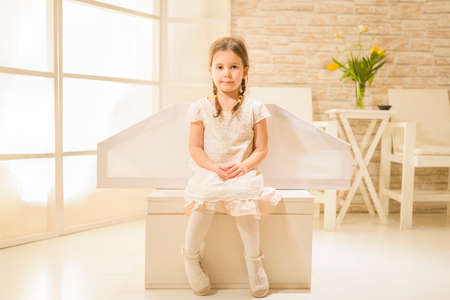 Little child girl plays astronaut. Child in an astronaut costume plays and dreams of becoming a spaceman. Children's play conceptの写真素材