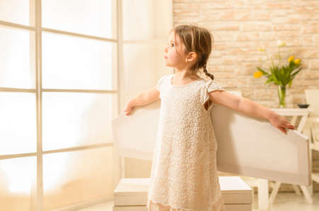 Little child girl plays astronaut. Child in an astronaut costume plays and dreams of becoming a spaceman. Children's play conceptの写真素材