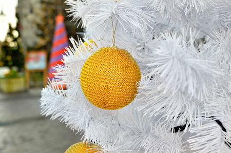 Yellow Christmas toy on a white fluffy tree. Christmas holidays and New Year's toys.の写真素材