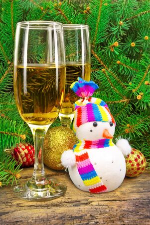 Wine glasses, snowman, Christmas toys, near  New Year tree.の写真素材