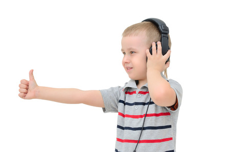 Little boy listening to headphones on a white backgroundの写真素材