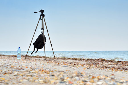 Photographic tripod is on the beach blue sea. Seascapes and photographic equipment.の写真素材