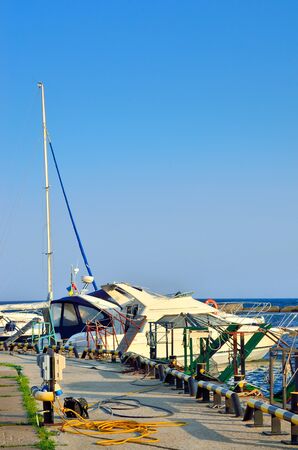 Yachts and boats moored on the sea quay. Marine Rigging and port equipment.の写真素材