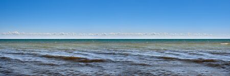 Panorama of sea waves on the background of dawnの写真素材
