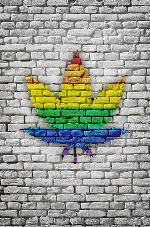 Multi-colored cannabis leaf on a multi-colored, brick wall. Rastaman flag.の写真素材