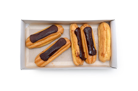 Eclairs with chocolate in a box on a white background.