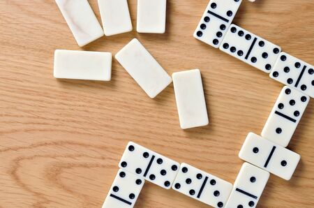 Playing dominoes on a wooden table. Dominoes game concept.の写真素材