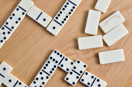 Playing dominoes on a wooden table. Dominoes game concept.の写真素材