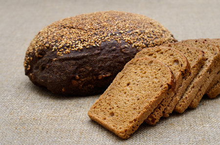 Whole grain rye bread slices on rustic linen clothの写真素材