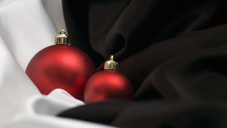 christmas decoration with ornaments arranged on white and black satinの写真素材