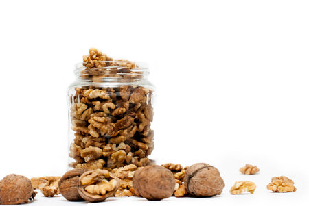 Transparent jar full of walnuts, on white background.の写真素材