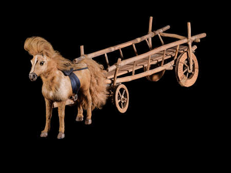 Vintage wooden cart model with horse isolated on black backgroundの写真素材