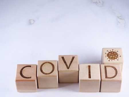 Virus concept on wooden blocks with written word COVID