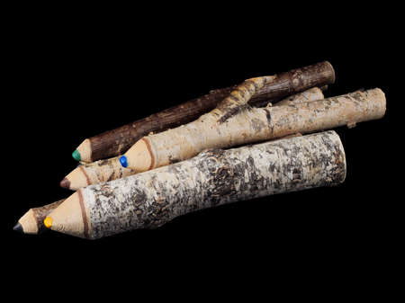 5 color pencils stylized from a branch isolated on a black backgroundの写真素材