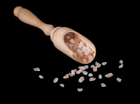 Wooden shovel with granulated sea salt isolated on blackの写真素材