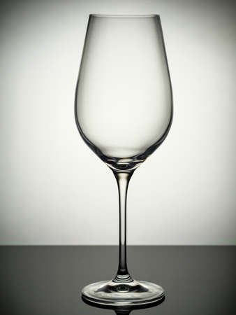 An empty champagne glass stands on a gray tableの写真素材