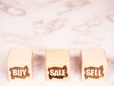 BUY, SELL and SALE symbols on wooden cubes as a sales management conceptの写真素材