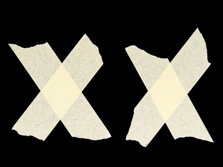 Folded cross-stitched pieces of adhesive tape isolated on a black backgroundの写真素材