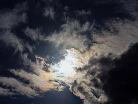 The sun shines into overcast dark yellow-blue storm cloudsの写真素材