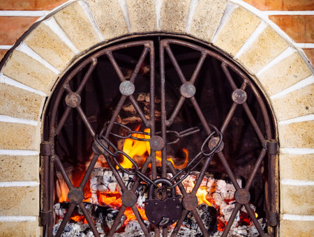 Burning firewood in a chained fireplace with a padlockの写真素材