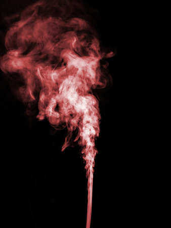 A jet of red smoke rises, streams and forms tubers on a black backgroundの写真素材
