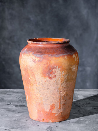 Old shabby ceramic jug on a gray concrete surfaceの写真素材