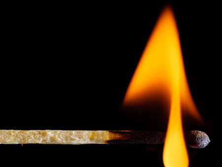 Orange fire of a wooden match isolated on a black backgroundの写真素材