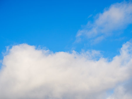 White fluffy soft clouds against a light blue skyの写真素材