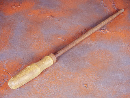 Old rusty round rasp with wooden handle on a grunge orange backgroundの写真素材
