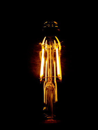 Glowing spiral of an incandescent lamp isolated on black backgroundの写真素材