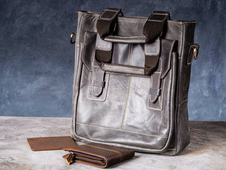 <p>Folding EDC knife and wallet with cardholder near a vintage leather casual bag</p>の写真素材