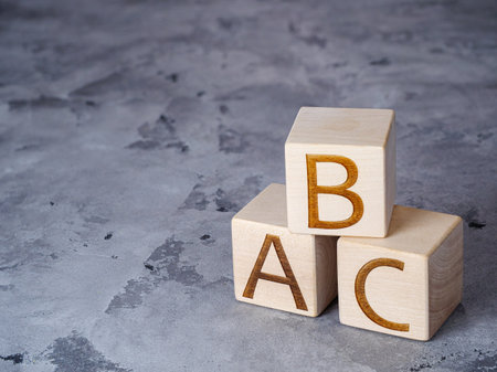 ABC text on wooden cubes on gray concrete backgroundの写真素材