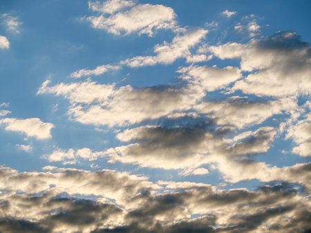 Overcast gray clouds in sunlight against a blue sky