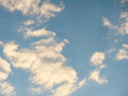 White clouds in sunlight against a blue skyの写真素材