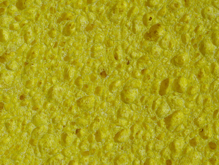 Texture of a porous yellow sponge in close-up as an abstract backgroundの写真素材