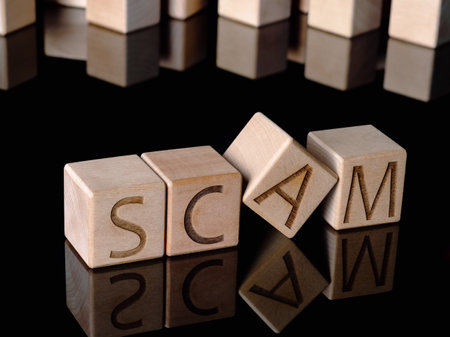 SCAM text on wooden cubes as a business fraud conceptの写真素材